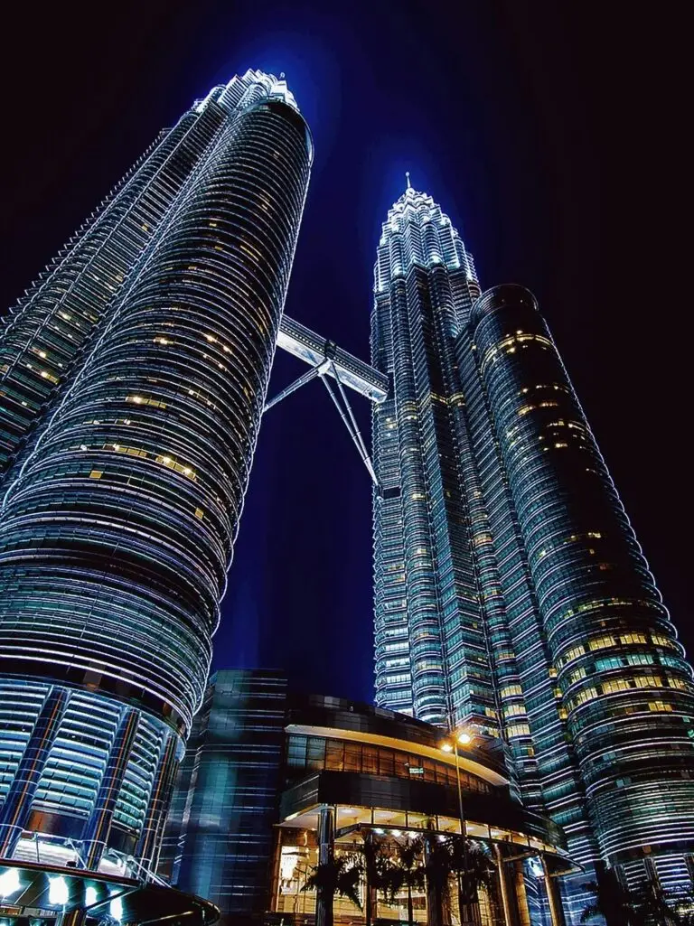 Stunning nighttime view of the illuminated Petronas Towers in Kuala Lumpur, Malaysia.